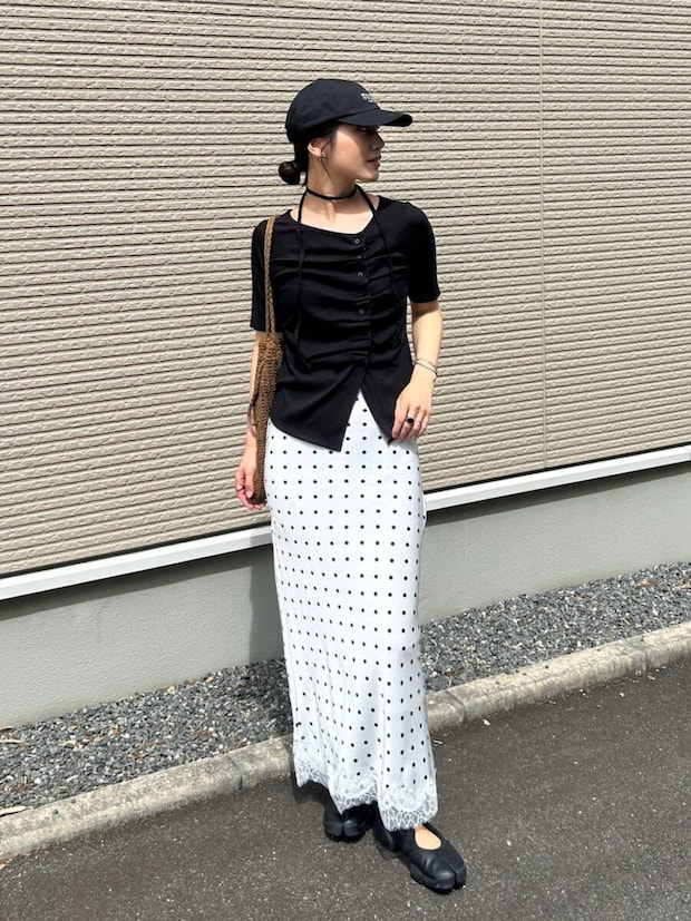 白ドット柄スカートに黒トップスとキャップを被った女性 白ドット柄スカートに黒トップスとキャップを被った女性