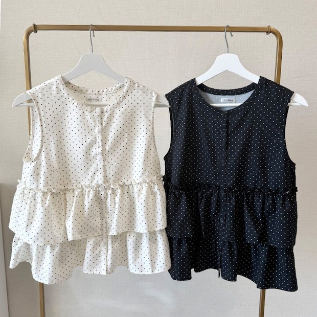 ハンガーにかけられた白と黒のドット柄ノースリーブブラウス2枚 ハンガーにかけられた白と黒のドット柄ノースリーブブラウス2枚