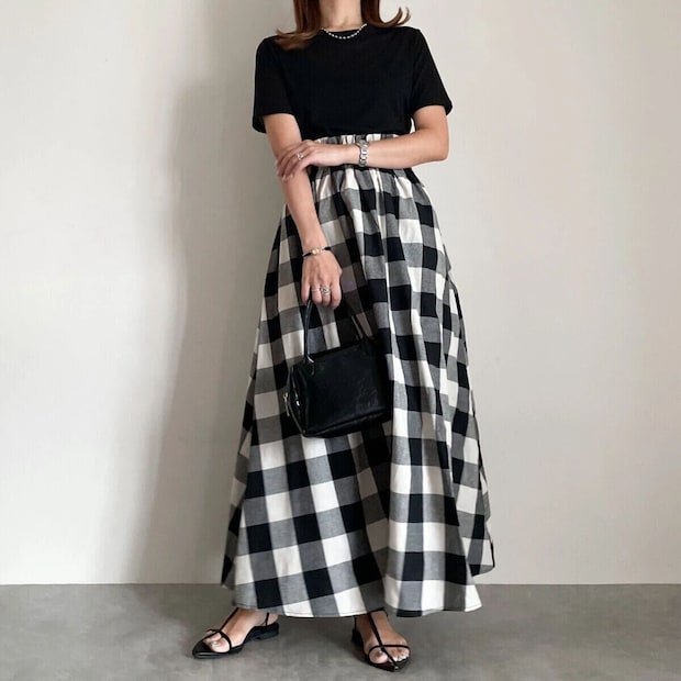 黒シアーTと白黒チェック柄スカートを着用した女性 黒シアーTと白黒チェック柄スカートを着用した女性