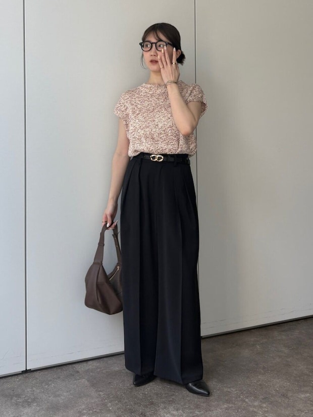 眼鏡の女性がピンクニットと黒ワイドパンツでポーズ 眼鏡の女性がピンクニットと黒ワイドパンツでポーズ