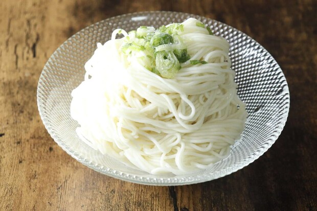 ガラスの器に盛られた白いそうめんと刻みネギ