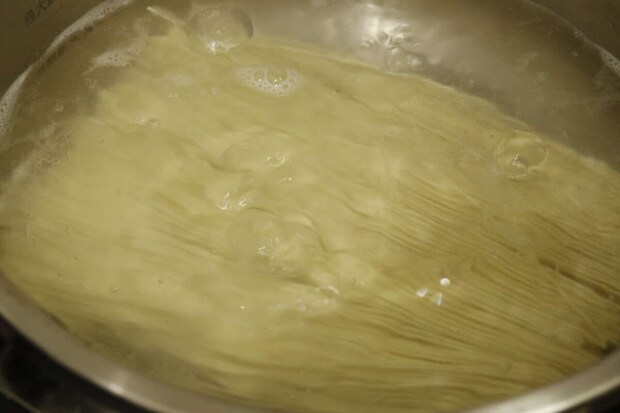 鍋の中で沸騰したお湯で棒ラーメンの麺が茹でられている様子