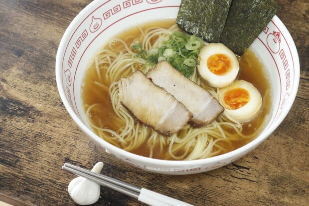 白い器に盛り付けられたラーメン。チャーシュー、煮卵、海苔、ネギがトッピングされている