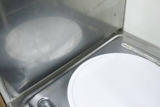 油汚れで曇っているキッチンのステンレス壁面とコンロ 油汚れで曇っているキッチンのステンレス壁面とコンロ