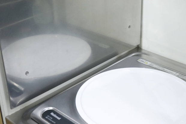 掃除後、ピカピカになったキッチンのステンレス壁面とコンロ 掃除後、ピカピカになったキッチンのステンレス壁面とコンロ