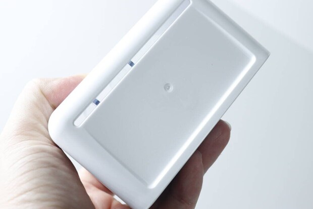白い歯ブラシチューブスタンドの底面。スリット状の水切り穴が見える。