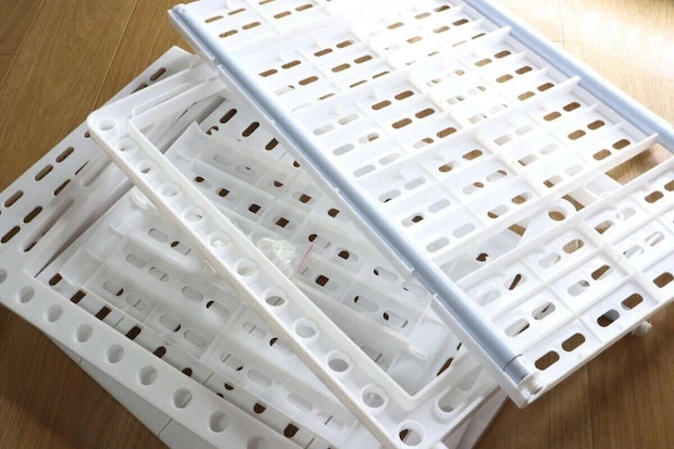 白いプラスチック製のシンク下すきま収納ラックの部品が積み重ねられている 白いプラスチック製のシンク下すきま収納ラックの部品が積み重ねられている