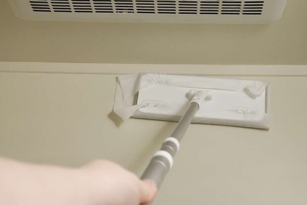 ワイパーにセットしたシートで浴室の壁を掃除している様子
