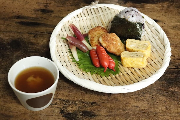 盆ざるに、おにぎり、卵焼き、ウインナーが盛り付けられたワンプレート