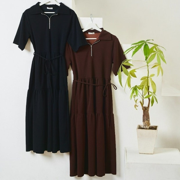 黒と茶色のハーフジップワンピースが2着、観葉植物の横に吊るされている 黒と茶色のハーフジップワンピースが2着、観葉植物の横に吊るされている