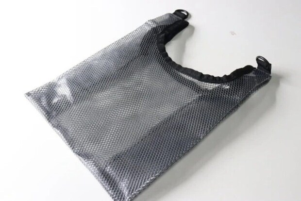 黒いメッシュ素材のビニールバッグが白い背景に置かれている 黒いメッシュ素材のビニールバッグが白い背景に置かれている