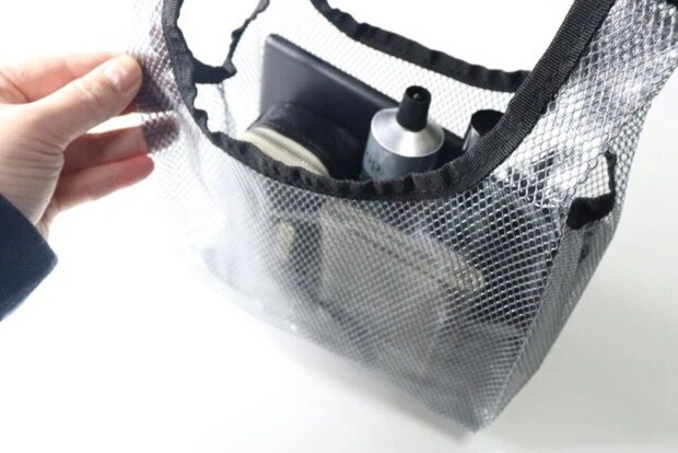 手が黒いビニールバッグの口を開け中身を見せている様子 手が黒いビニールバッグの口を開け中身を見せている様子