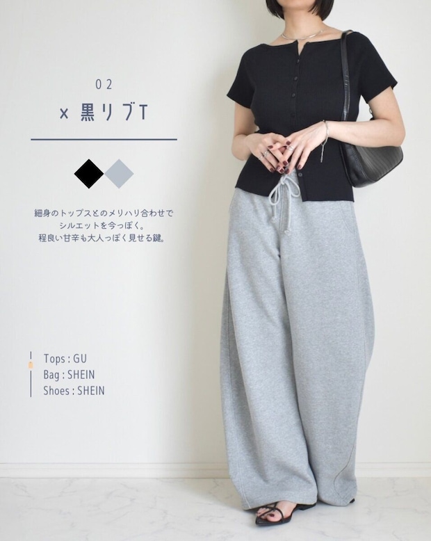 黒いリブTシャツとグレーのスウェットパンツを着た女性