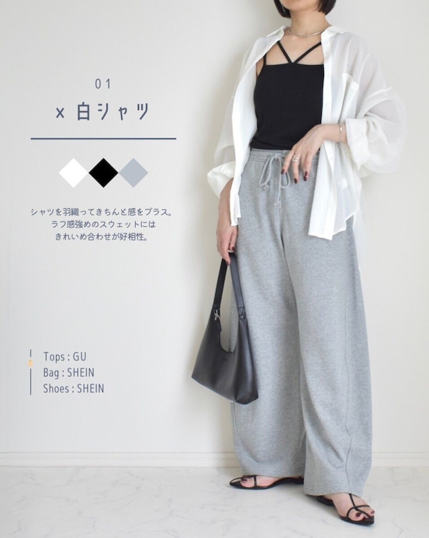 白いシャツと黒キャミ、グレーのスウェットパンツを着た女性