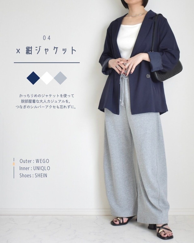 紺ジャケットと白インナー、グレーのスウェットパンツを着た女性