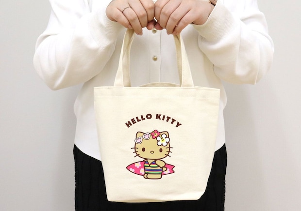白い服の女性がハローキティのミニトートバッグを手に持っている 白い服の女性がハローキティのミニトートバッグを手に持っている