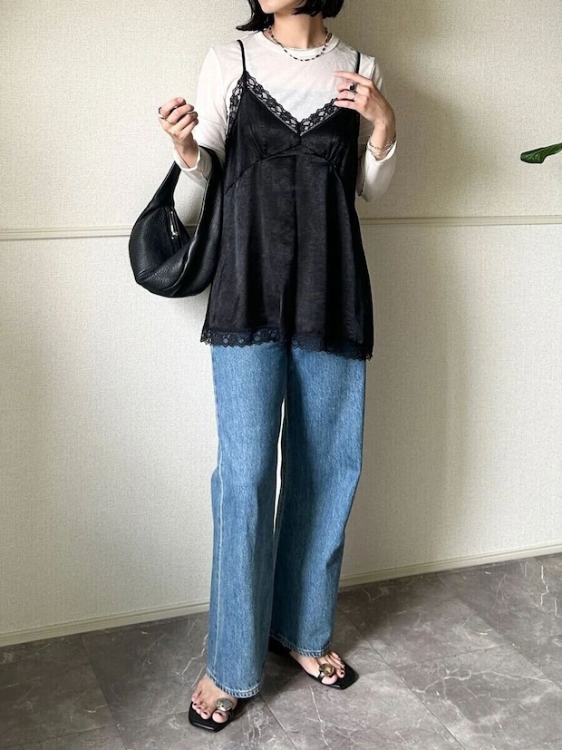 白ロンTとデニムに黒サテンキャミを重ね着した女性 白ロンTとデニムに黒サテンキャミを重ね着した女性