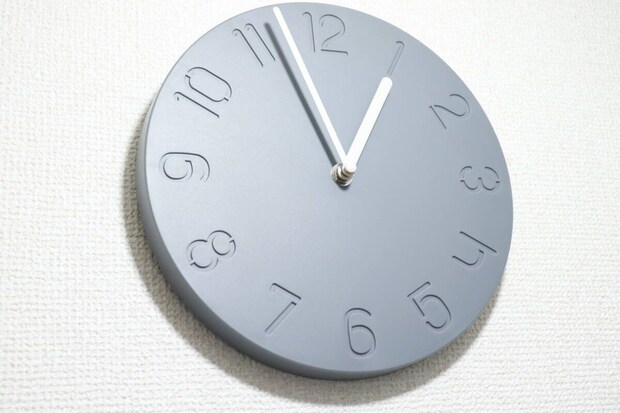 白い壁に掛けられたグレーの掛け時計 白い壁に掛けられたグレーの掛け時計