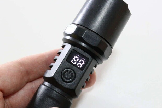 手に持った黒い懐中電灯のディスプレイにバッテリー残量「88」が表示されている