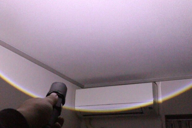 暗い部屋で懐中電灯の光が広範囲を照らしている様子