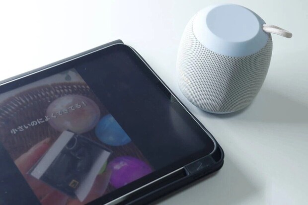 タブレットの横に置かれたライトブルーのBluetoothスピーカー タブレットの横に置かれたライトブルーのBluetoothスピーカー