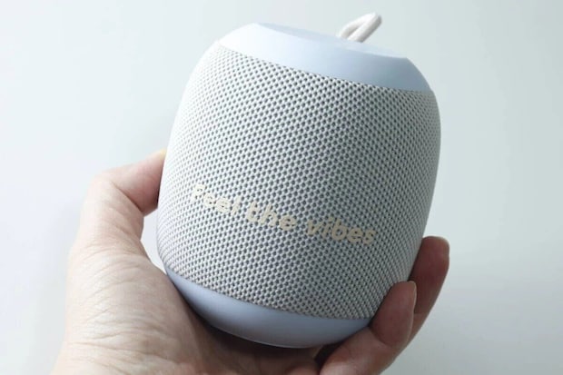手のひらに乗せられた丸いライトブルーのBluetoothスピーカー 手のひらに乗せられた丸いライトブルーのBluetoothスピーカー