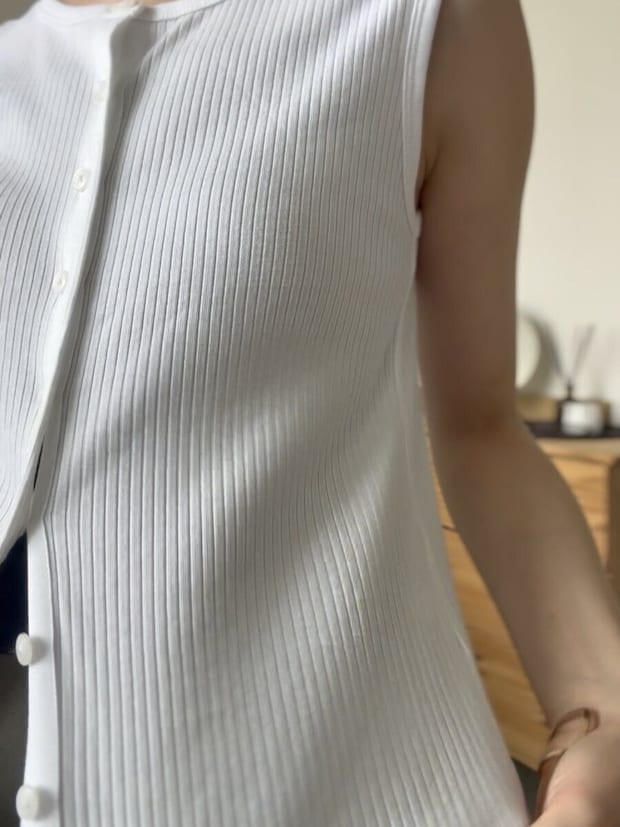 白いリブノースリーブを着た女性の斜めからの胸元アップ