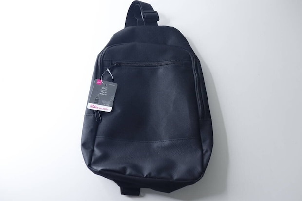 白い背景に置かれた黒い斜めかけバッグと商品タグ 白い背景に置かれた黒い斜めかけバッグと商品タグ