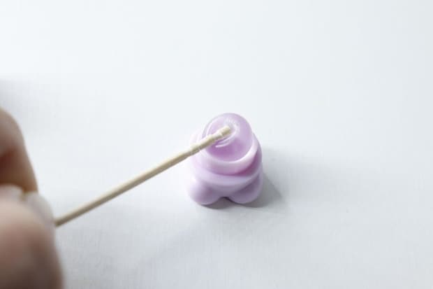くまちゃん形のミニリップブラシのシリコーンブラシ部分を綿棒で拭いている様子 くまちゃん形のミニリップブラシのシリコーンブラシ部分を綿棒で拭いている様子