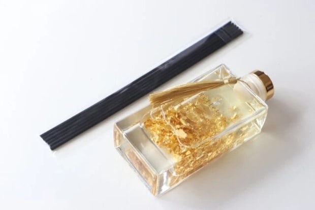 金箔が入ったアロマディフューザーのボトルと黒いスティック