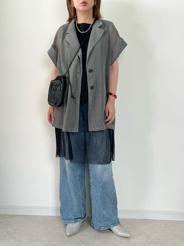 グレーのシアー半袖ジャケットとワイドデニムを着用した女性の全身