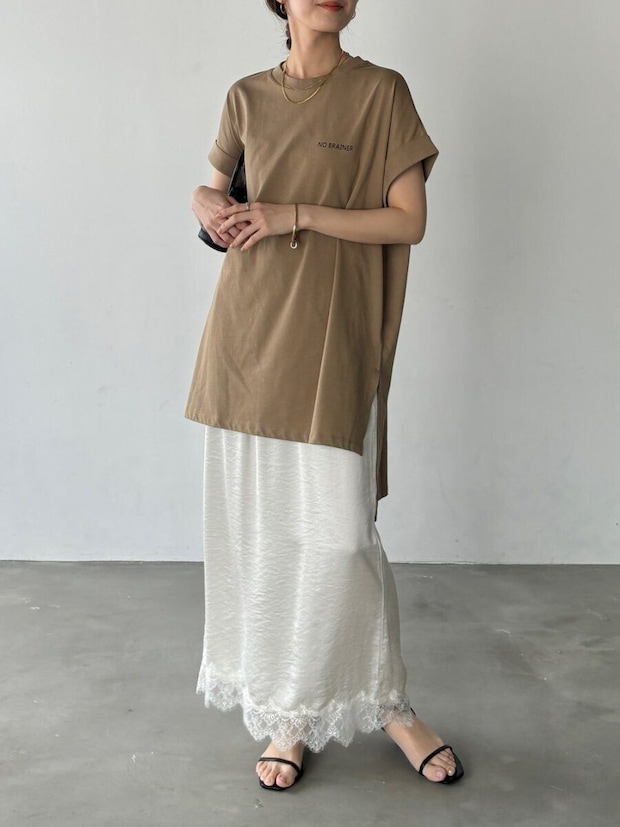 茶色のチュニックTシャツと白のレース裾ナロースカートを着用した女性の全身