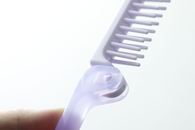指で持たれたヘアブラシの折りたたみ部分の接合部 指で持たれたヘアブラシの折りたたみ部分の接合部