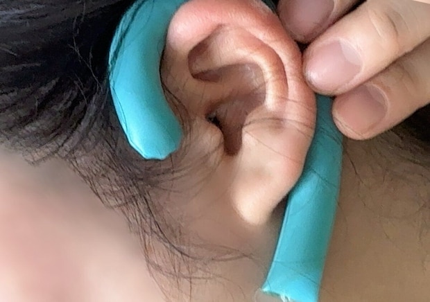 女性が耳裏ひんやりパッドを耳にかけて装着しているクローズアップ