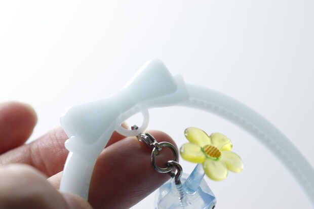 チャームスタンドの輪にカニカンでチャームを取り付ける手元