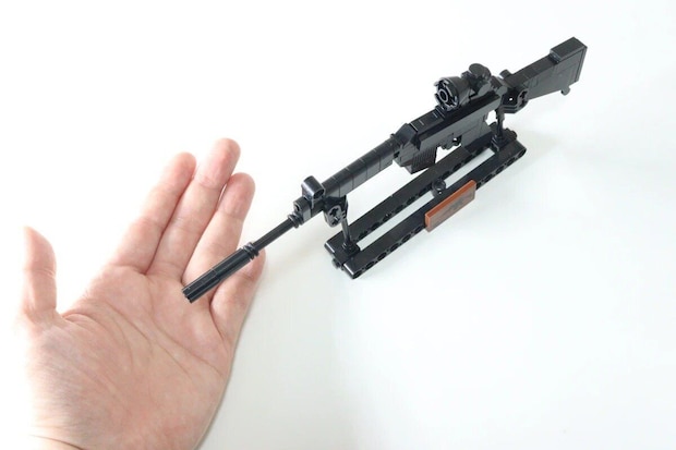 完成したブロック銃が台座に置かれ、手のひらと比較