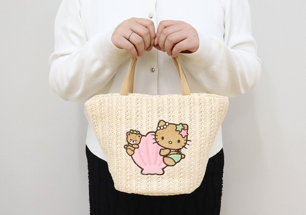 白い服を着た女性が日焼けハローキティのかごバッグを持っている 白い服を着た女性が日焼けハローキティのかごバッグを持っている