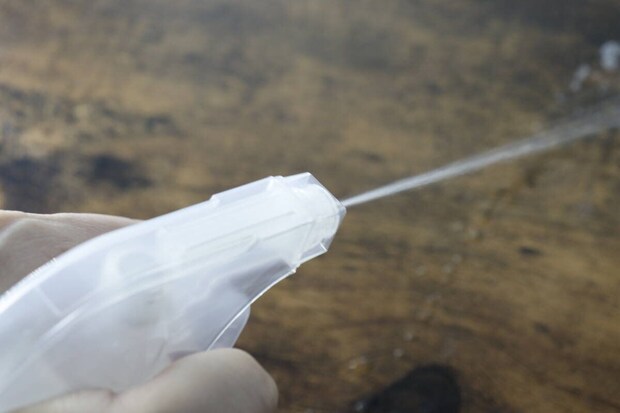 スプレー容器から直線状に液体が勢いよく噴射されている スプレー容器から直線状に液体が勢いよく噴射されている