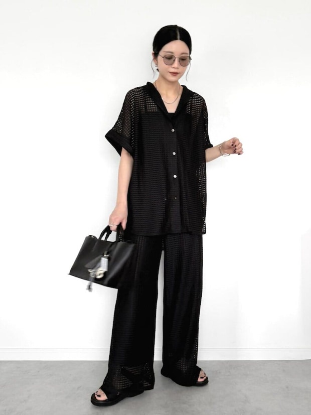 メッシュ素材の黒シアーシャツと黒ワイドパンツのオールブラックコーデの女性 メッシュ素材の黒シアーシャツと黒ワイドパンツのオールブラックコーデの女性