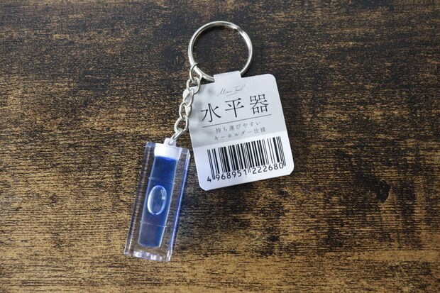 木目調の台に置かれたセリアのキーホルダー水平器と商品タグ