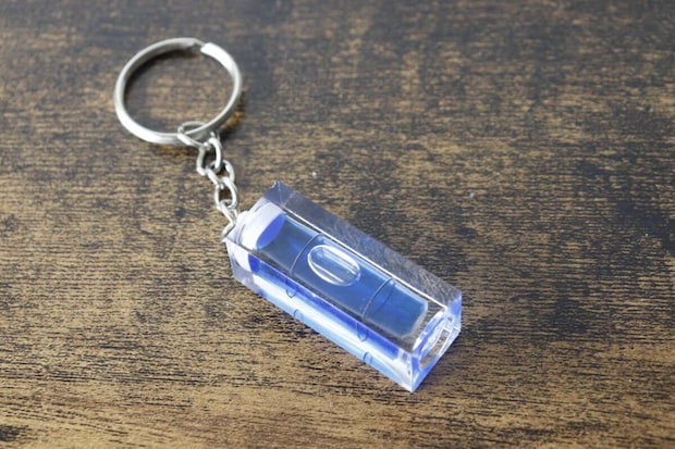 木目調の台に置かれたキーホルダー水平器を斜め上から撮影