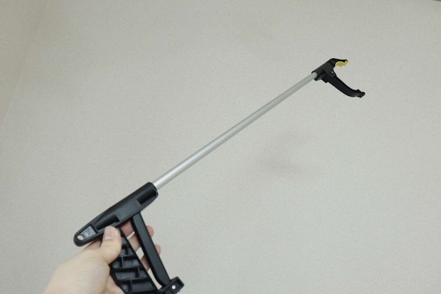 白い壁を背景に、なんでもキャッチャーを持つ手