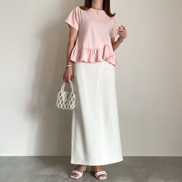 ピンクのペプラムトップスと白Iラインスカート、白いバッグの大人コーデ。 ピンクのペプラムトップスと白Iラインスカート、白いバッグの大人コーデ。