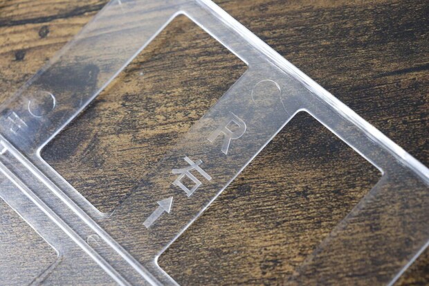 缶ボトルホルダーの透明な板に印字された「→右」の文字