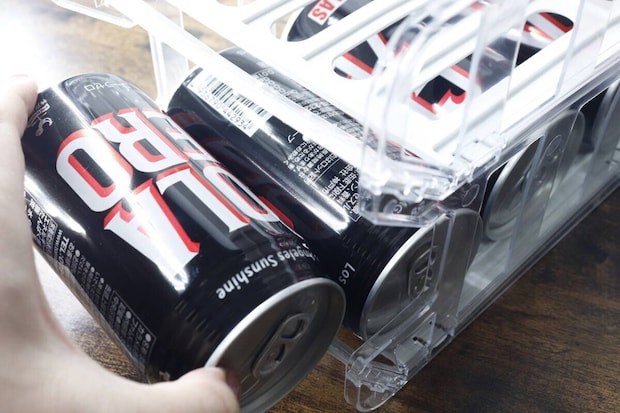 缶ボトルホルダーから黒い缶ドリンクを取り出す手元 缶ボトルホルダーから黒い缶ドリンクを取り出す手元