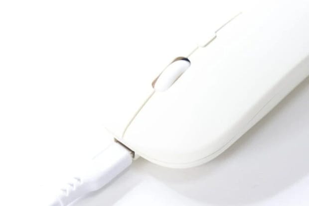 白い無線マウスの充電ポートにUSB Type-Cケーブルが挿し込まれている 白い無線マウスの充電ポートにUSB Type-Cケーブルが挿し込まれている