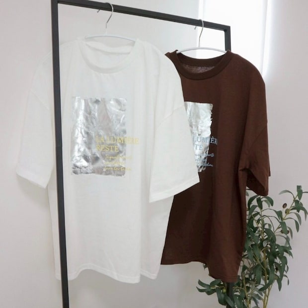 白と茶色のプリントTシャツがハンガーラックにかけられている 白と茶色のプリントTシャツがハンガーラックにかけられている