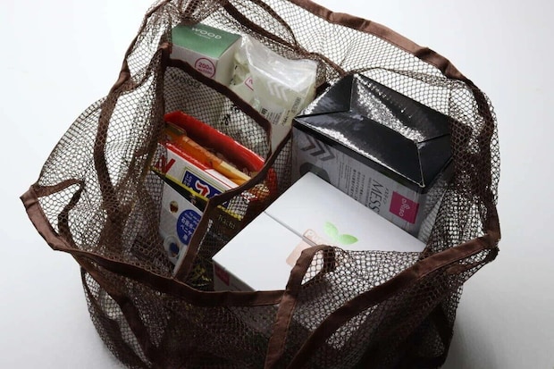 茶色のメッシュバッグに、仕切りを使って様々な商品が収納されている様子