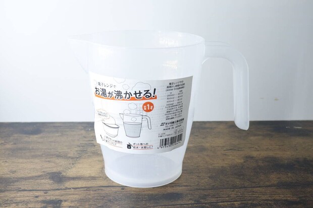 商品パッケージが貼られた透明な計量カップが木目のテーブルに置かれている