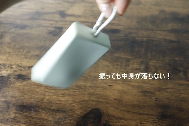 中身が入ったケースを振っても落ちないことを示す手元